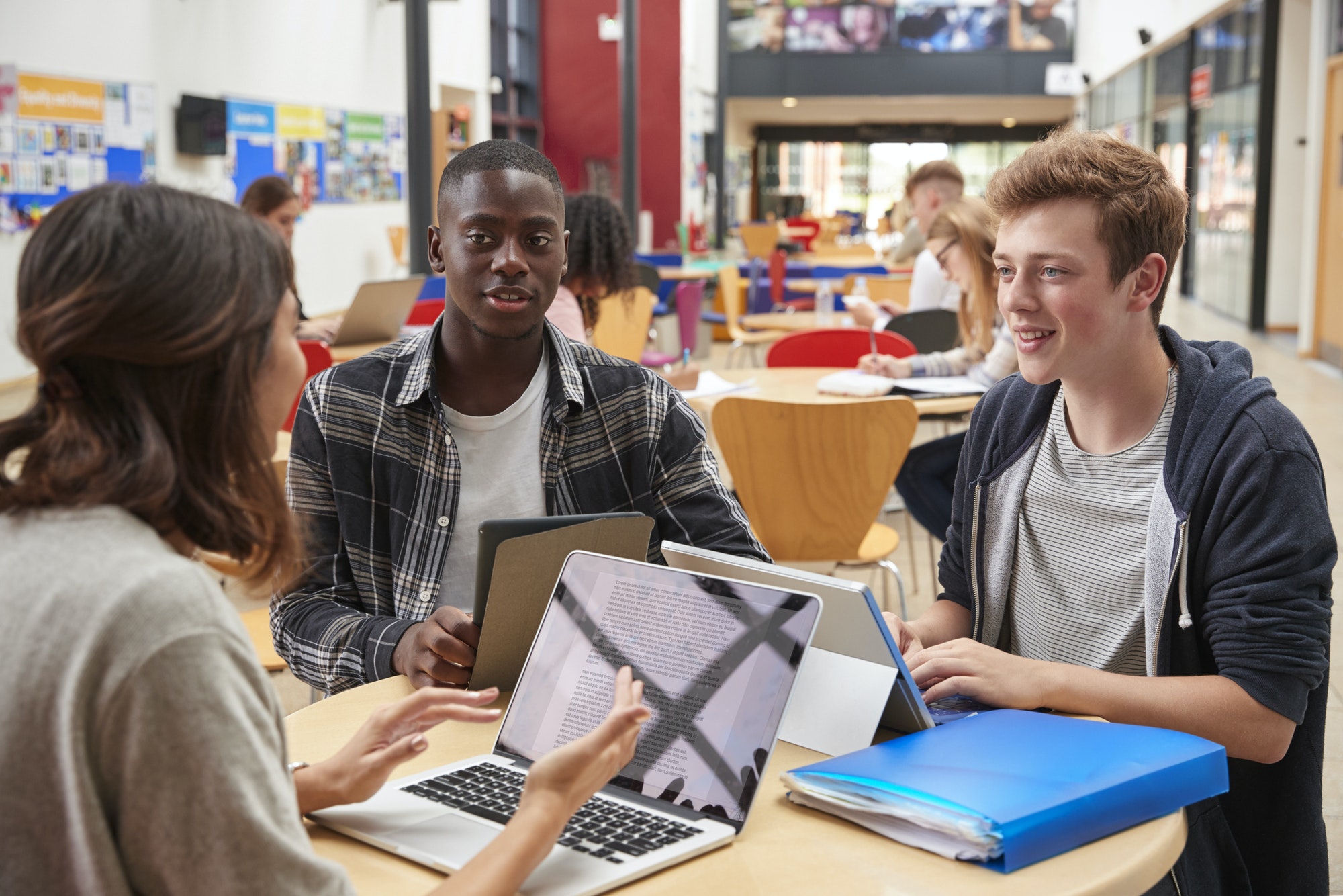 teacher-talks-to-students-in-communal-area-of-college-campus